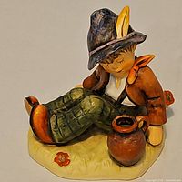 Front view of Goebel Hummel Coffee Break figurine showing seated boy, jug, base detail