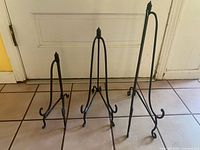 Three cast iron book stands side by side showing graduated sizes