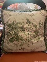 Full view of square pillow showing floral design and fringe