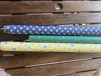 Three of the wallpaper rolls showing different colorways and patterns