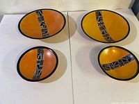 Four soapstone plates laid out, showing colors and patterns