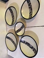 Five white soapstone plates displayed on wall, showing size variation and design