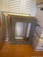 Three nested empty frames leaning against wall