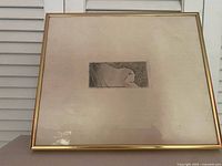 Frontal view of framed drawing with mat and gold frame