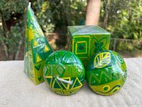 Group of four candles: pyramid, square, two spherical, showing colors and patterns