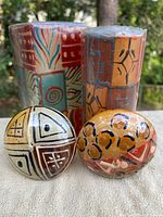Two pillar candles and two ball candles with shrink wrap showing painted designs