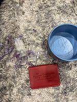 String lights, blue Stitch tin container interior, red wallet displayed on rug