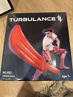Front of box showing Turbulance branding and image of red inflatable sword