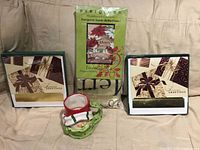 Front view showing two boxed greeting card sets, packaged Evergreen garden flag, and snowman mug