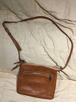 Full view of brown Fiorelli crossbody purse showing adjustable strap and exterior zip pocket