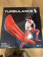 Front of box showing Turbulance branding, red inflatable sword graphic, note of 2 swords included