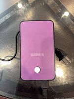 Top view showing purple panel with Jamberry logo and power button plus attached cord