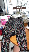Full view of multicolour geometric print leggings laid flat on table