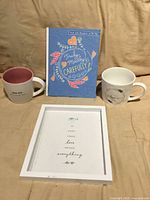Front view of mugs, frame and book
