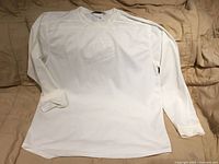 Front view of white Nike sweater laid flat showing overall design and embossed chest logo