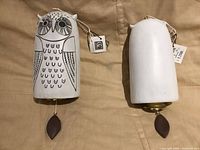 Front and rear views of two ceramic owl hanging bells with tags