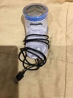 Front view of portable clothing shaver with cable coiled