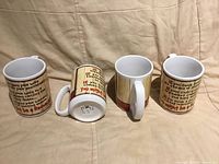 Four matching novelty mugs displayed to show exterior graphics and interior, one mug on side revealing bottom retail sticker