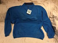 Front view of blue Eddie Bauer fleece sweater with tag attached