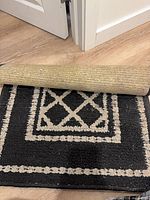Runner rug rolled to show jute backing and geometric design