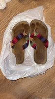 Top view of both sandals showing plaid straps, worn footbeds, size indication inferred