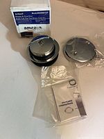 Full kit showing box, drain stopper assembly, overflow plate, instructions