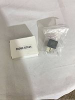 Relay in plastic bag beside labeled white box