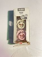 Front of retail box showing two pacifiers and branding