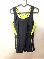 Front view of black and neon yellow one-piece swimsuit on hanger