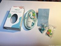 Retail box, oval case with trimmer, instruction leaflet, two bags of filing pads