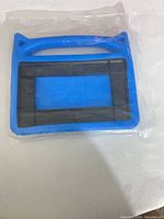 Front view of blue silicone cat-ear tablet case in sealed bag