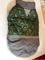 Front view of forest green quilted dog coat showing gray collar and hem