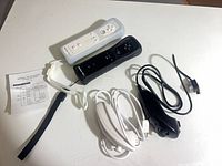 Lot overview showing both remotes, nunchuks, straps, and instruction sheet