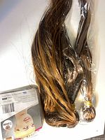 Two wefted hair bundles with caramel highlights plus packaging sleeve