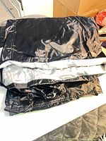 Folded black nylon/polyester cover showing silver inner lining
