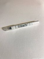 Full view of sealed NYX Jumbo Eye Pencil lying flat