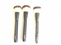 Three NYX Professional Makeup brushes, two loose, one sealed