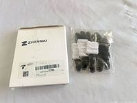 Front view of Zhanmai box and sealed bag containing three elastic straps with six clips