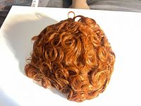 Top view of copper-auburn curly wig showing overall curl pattern
