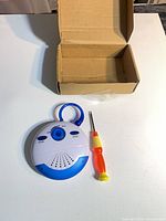 Front view of radio, screwdriver, and box