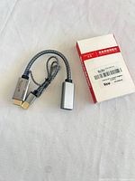 Adapter with connectors and box on white surface