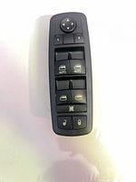 Front view showing directional pad, mirror select buttons, four window switches, lock buttons