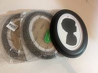 Three Vosarea oval frames, two wrapped, one unwrapped showing silhouette insert