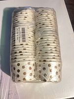 Front view of sealed package showing two stacks of white liners with gold dots
