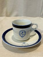 Cup on saucer showing crest and blue rim