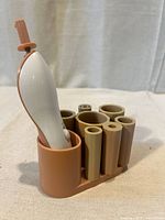 Brush cleaner handle inserted in base with collars visible