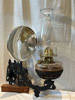 Complete assembly: oil lamp on cast iron wall bracket with attached mercury glass reflector