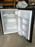 Fridge open showing shelves, drawer, door racks