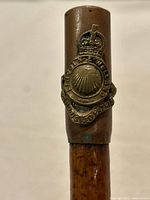 Close-up of brass sleeve and regimental badge on swagger stick