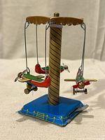 Front view of tin airplane carousel showing mast, base and airplanes